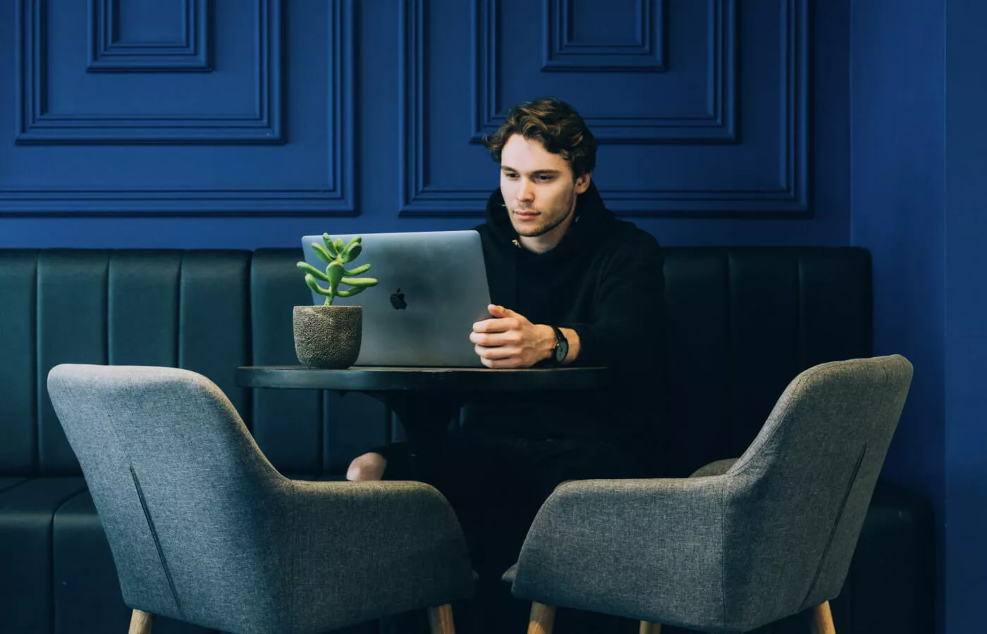 Man with laptop sitting on a wall